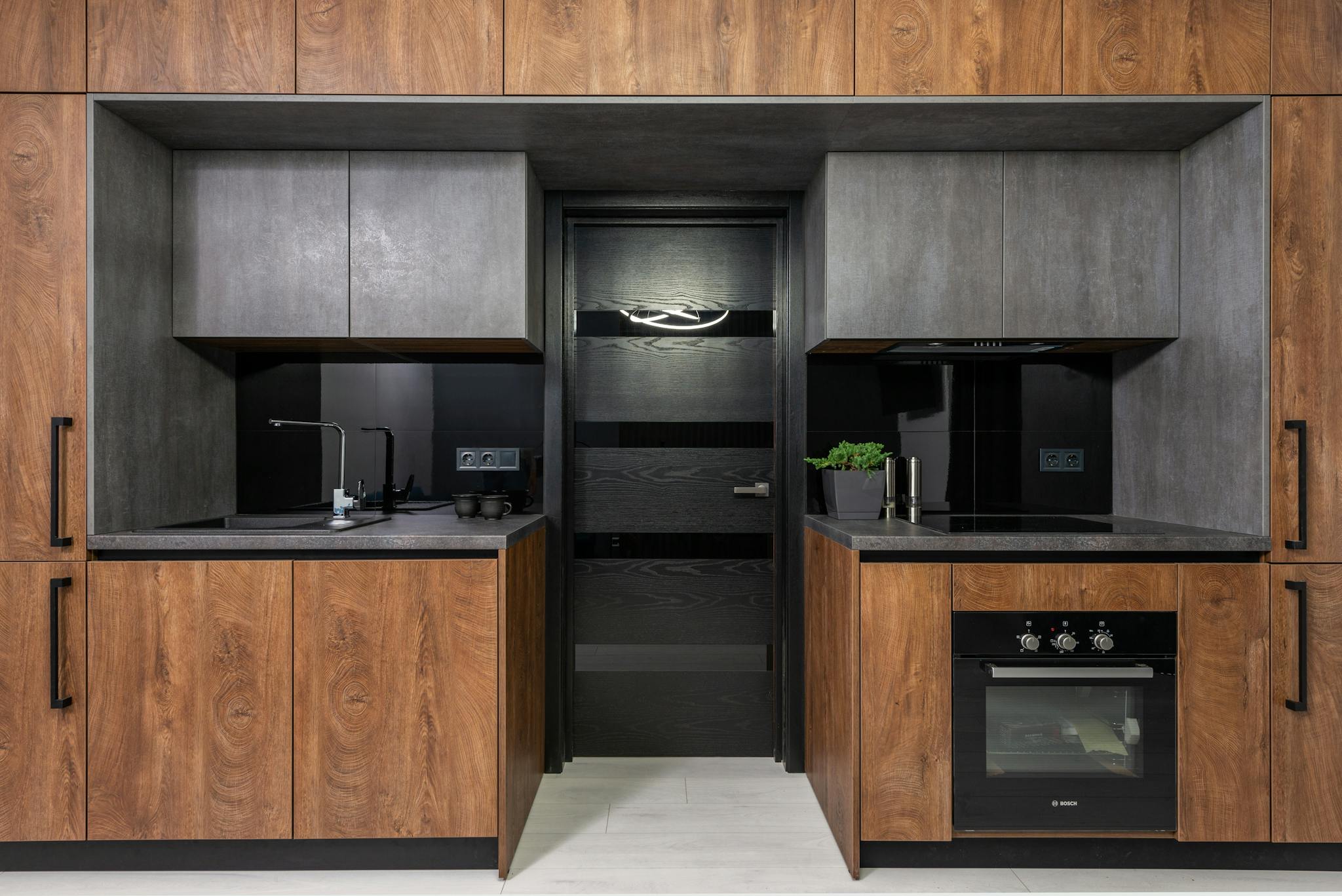 Sleek modern kitchen with wood and grey tones, highlighting minimalist style.